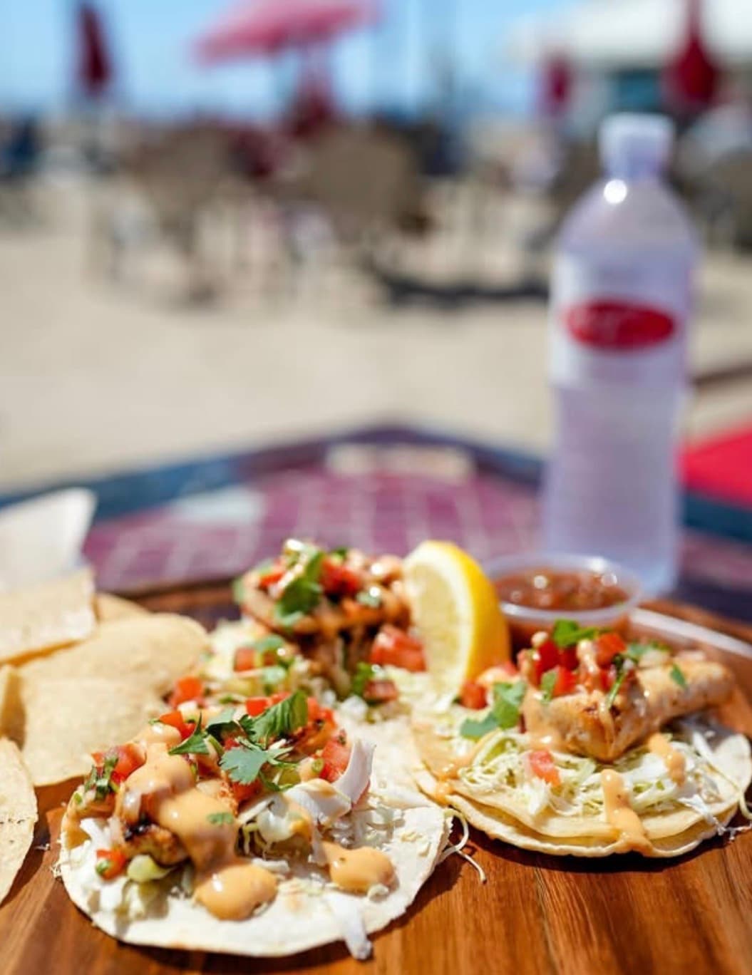 Grilled fish tacos with pico de gallo and chipotle crema, served by the water
