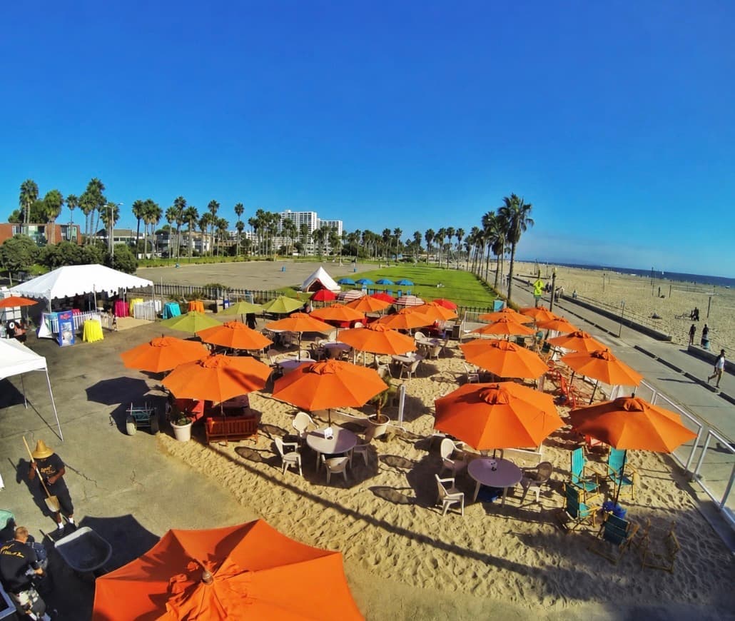 Aerial view of the café patio with orange umbrellas lined along the beach